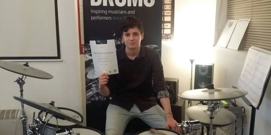 A drum student with his graded drum certificate at Rīgas Privātā Mūzikas Skola in Riga