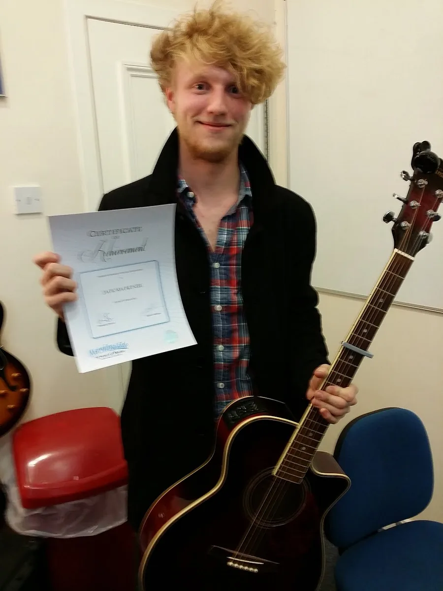 A guitar student with his graded music certificate at Rīgas Privātā Mūzikas Skola in Riga